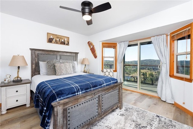 bedroom featuring access to exterior, a ceiling fan, and wood finished floors