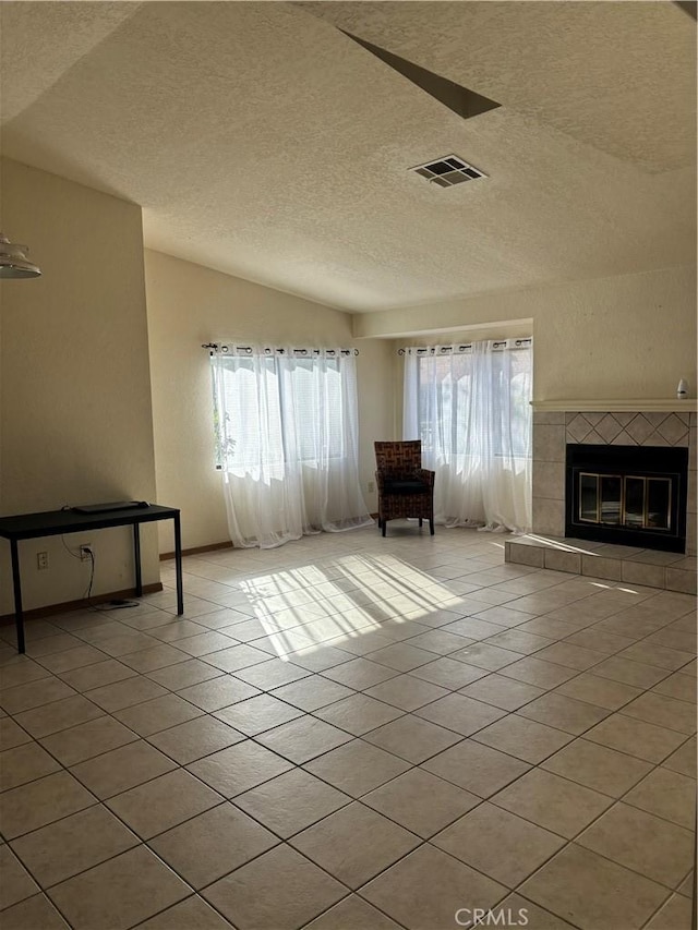 unfurnished living room featuring light tile patterned floors, a textured ceiling, and a fireplace