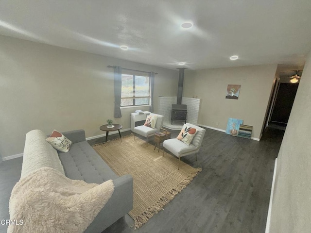 living room with dark wood-type flooring and a wood stove