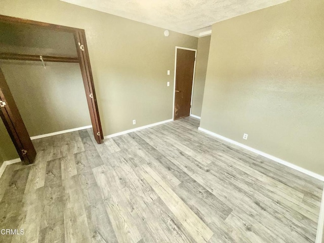 unfurnished bedroom featuring light hardwood / wood-style flooring and a closet