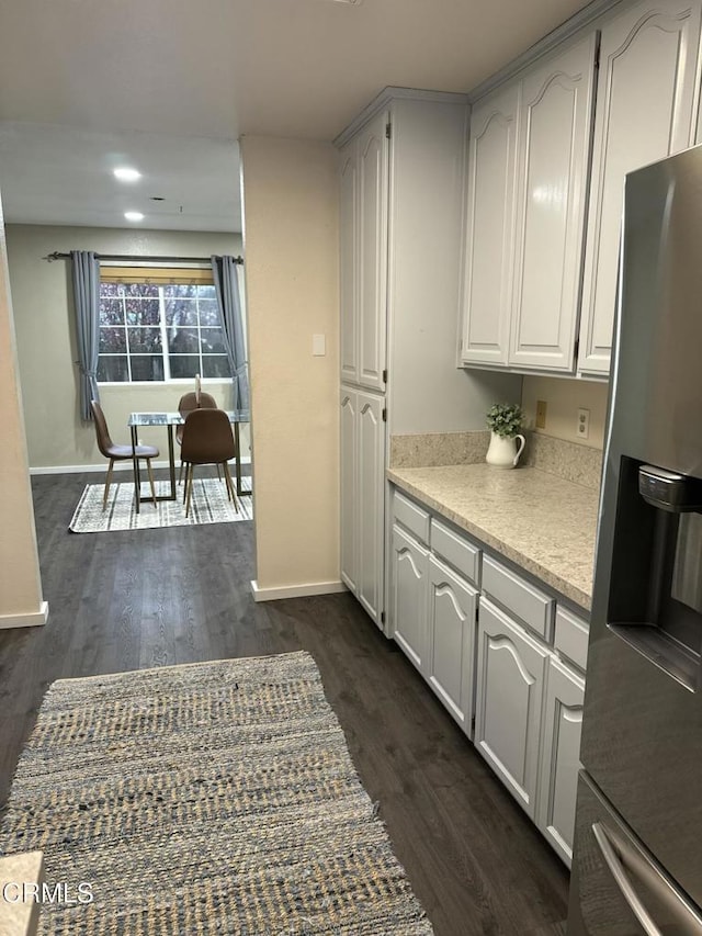 kitchen featuring white cabinets, dark hardwood / wood-style floors, and stainless steel fridge