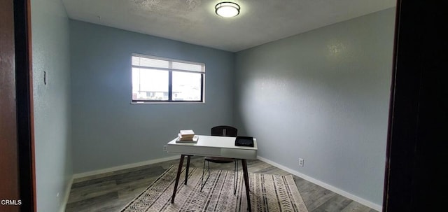 office space with baseboards and wood finished floors