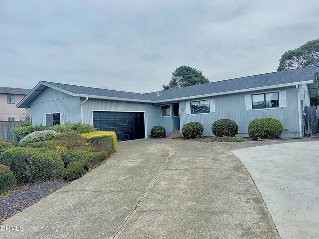 single story home with fence, driveway, a shingled roof, and a garage