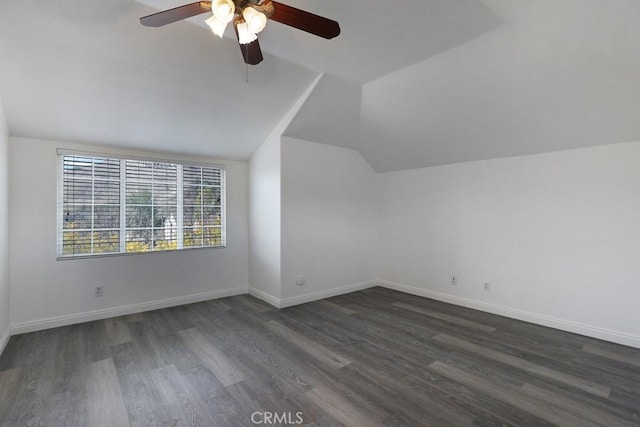 additional living space featuring lofted ceiling, dark wood-type flooring, and baseboards