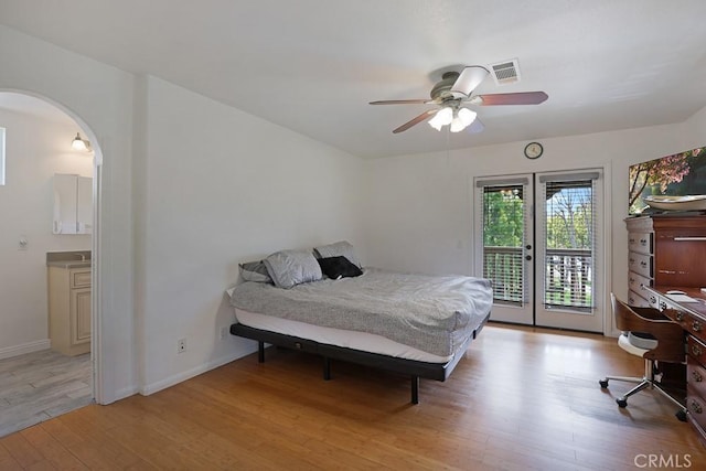 bedroom featuring arched walkways, visible vents, baseboards, access to exterior, and light wood finished floors