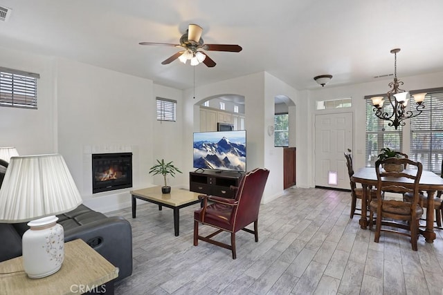 living area with light wood-style floors, visible vents, a fireplace, and baseboards