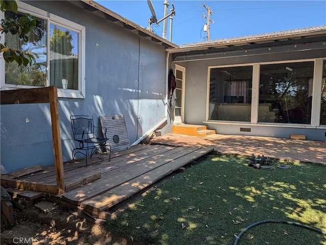 rear view of house featuring a patio area, a deck, and a lawn