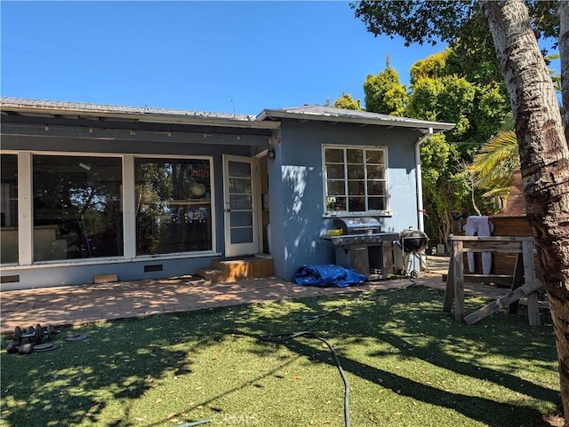 rear view of property with a lawn and a patio area