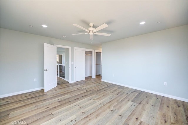 unfurnished bedroom featuring ceiling fan, a closet, and light hardwood / wood-style flooring