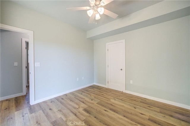 empty room with ceiling fan and light hardwood / wood-style flooring