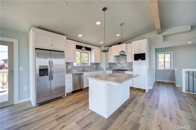 kitchen with sink, decorative light fixtures, a center island, appliances with stainless steel finishes, and white cabinets