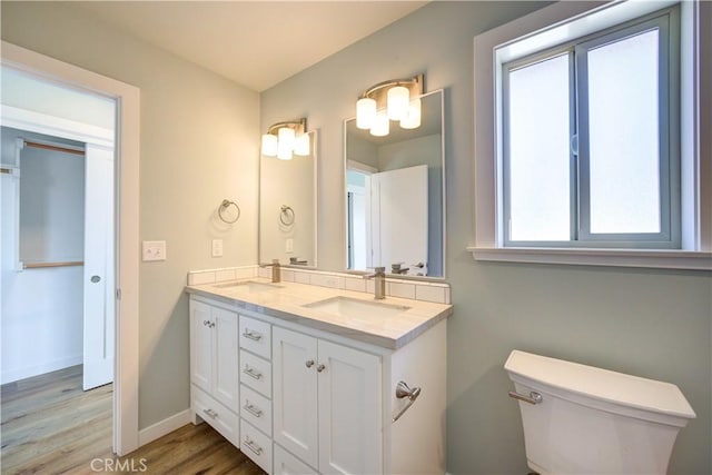 bathroom with vanity, wood-type flooring, and toilet
