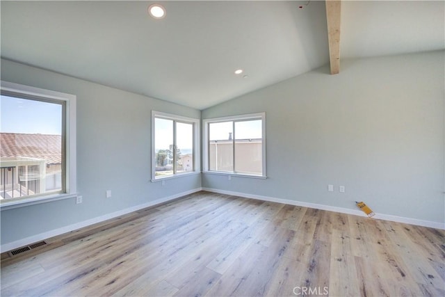 spare room with lofted ceiling with beams and light wood-type flooring