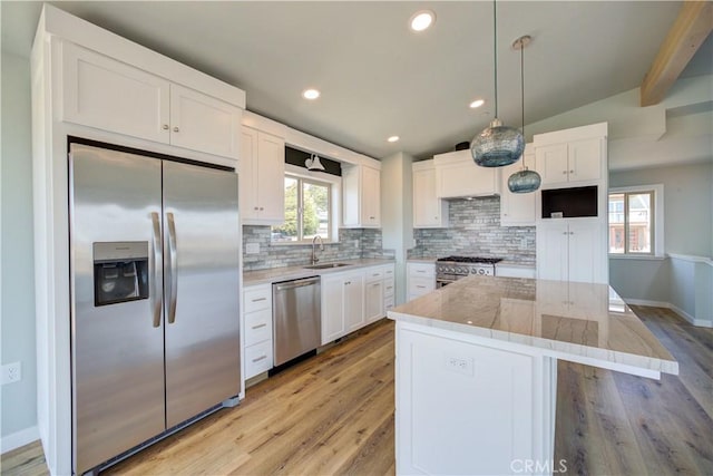 kitchen featuring stainless steel appliances, a center island, hanging light fixtures, and white cabinets