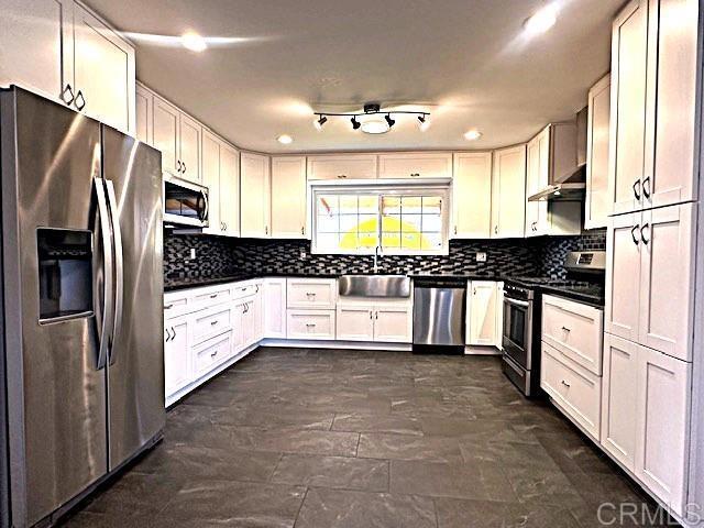 kitchen featuring appliances with stainless steel finishes, sink, and white cabinets