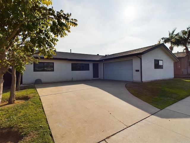 single story home featuring a garage, driveway, a front yard, and stucco siding