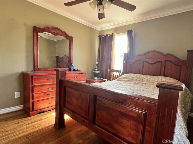 bedroom featuring baseboards, wood finished floors, a ceiling fan, and crown molding