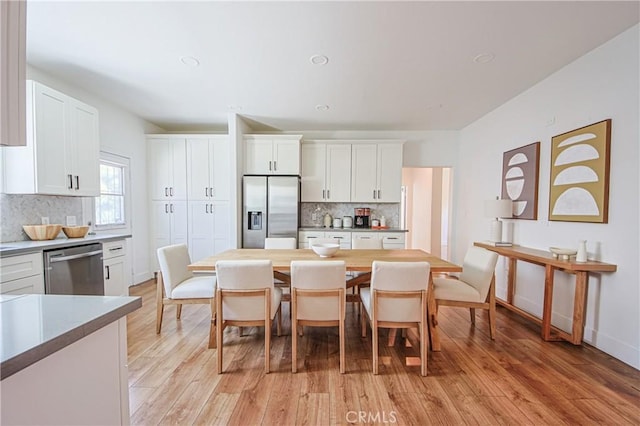 kitchen with butcher block counters, appliances with stainless steel finishes, white cabinets, light hardwood / wood-style floors, and backsplash