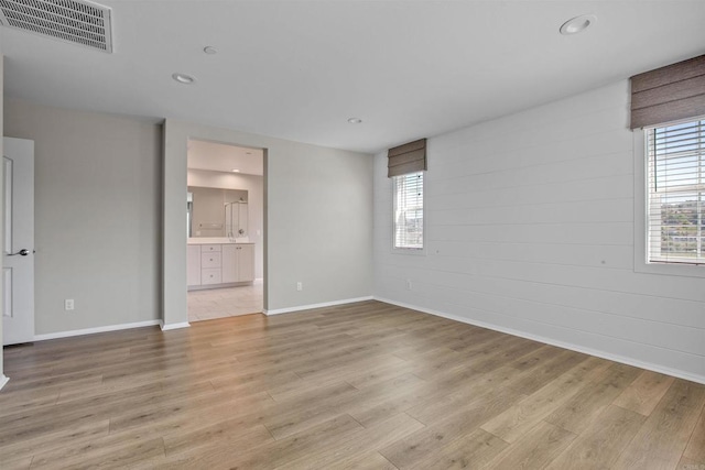 unfurnished bedroom with baseboards, light wood finished floors, visible vents, and recessed lighting