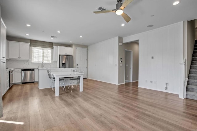 kitchen featuring a breakfast bar area, visible vents, white cabinetry, appliances with stainless steel finishes, and a center island