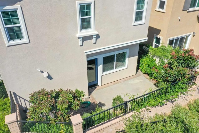 doorway to property featuring visible vents and stucco siding