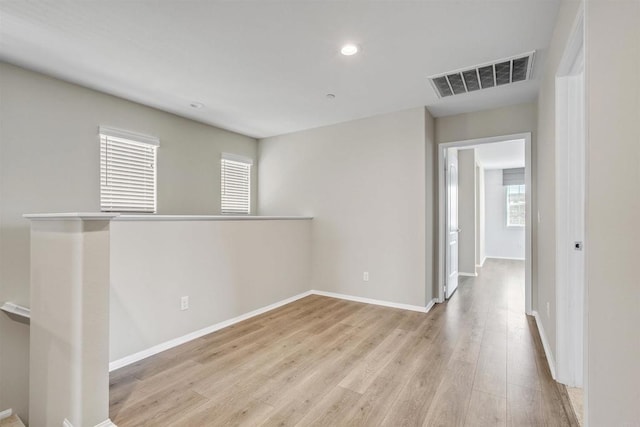 spare room featuring light wood-type flooring, baseboards, visible vents, and recessed lighting