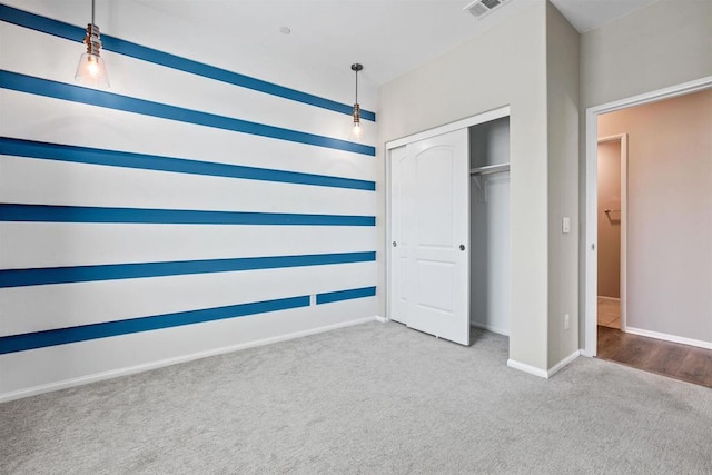 unfurnished bedroom with carpet, a closet, visible vents, and baseboards