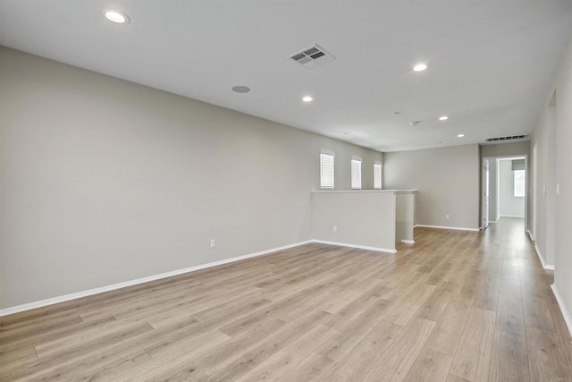 spare room featuring light wood-style flooring, visible vents, and recessed lighting