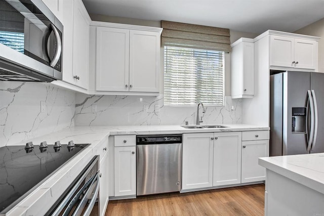 kitchen featuring white cabinetry, appliances with stainless steel finishes, and a sink