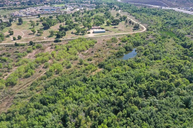 drone / aerial view with a forest view and a water view