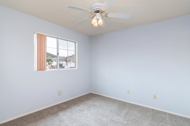spare room featuring baseboards, a ceiling fan, and carpet