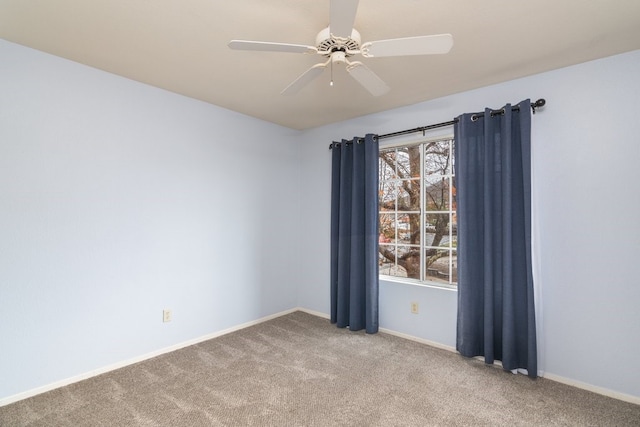 unfurnished room with ceiling fan and carpet