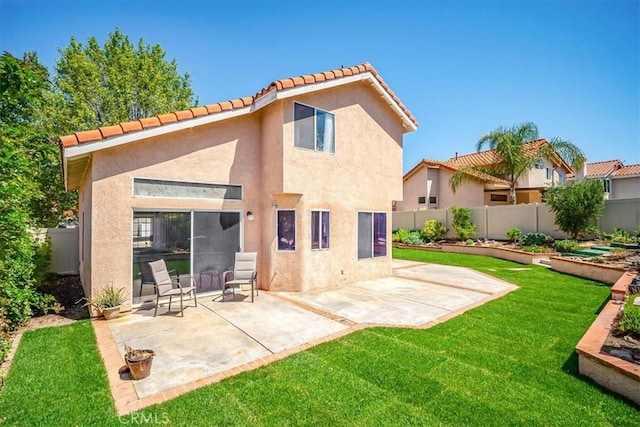 rear view of house with a lawn, a patio, fence, and stucco siding