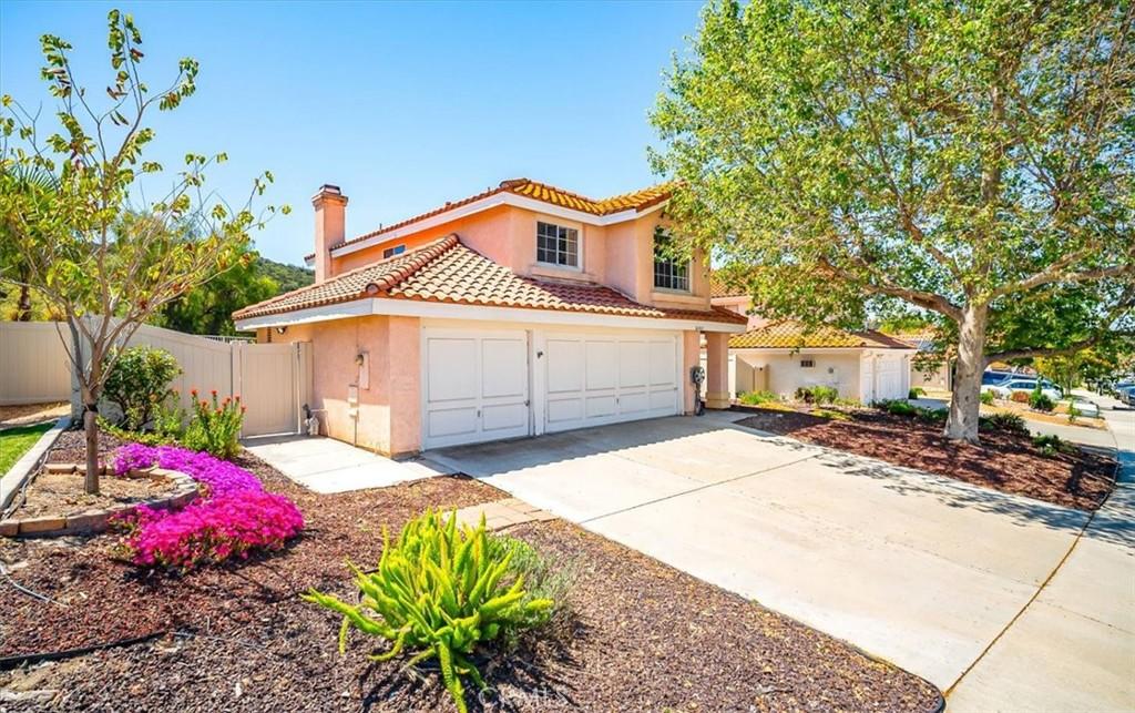 26945 Contignac Dr, Murrieta, CA 92562 - view of front of home with fence, stucco siding, a chimney, a tiled roof, and driveway