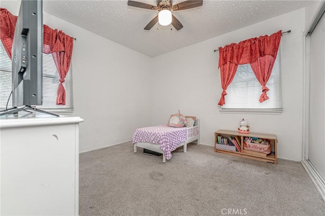 bedroom featuring ceiling fan, carpet floors, and a textured ceiling