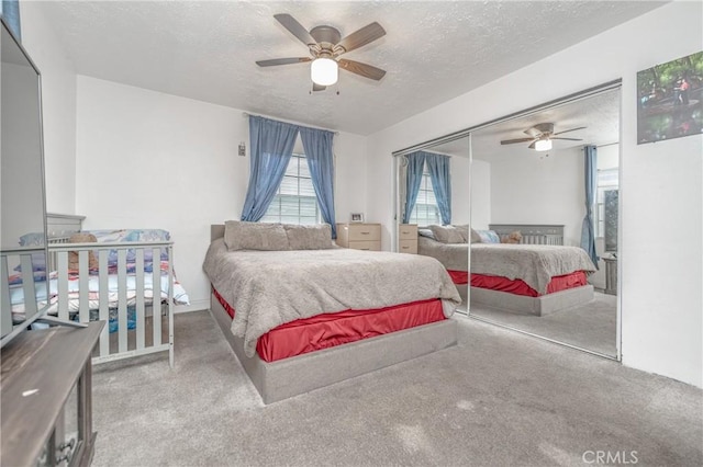 carpeted bedroom featuring ceiling fan, a textured ceiling, and a closet