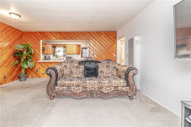 carpeted living room featuring wooden walls