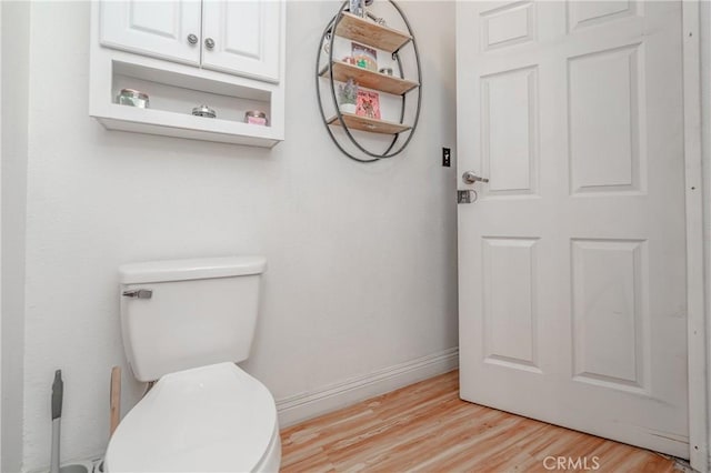 bathroom with hardwood / wood-style floors and toilet