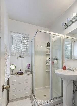 bathroom with tile patterned flooring and a shower with door