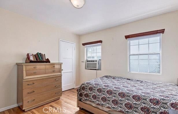 bedroom featuring cooling unit and light wood-type flooring