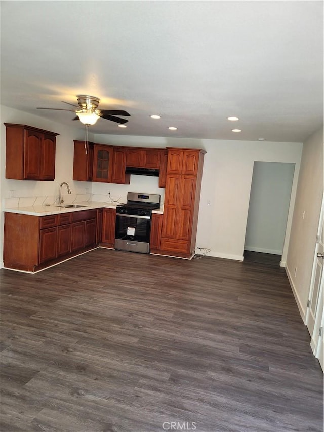 kitchen with ceiling fan, dark hardwood / wood-style floors, sink, and stainless steel gas range oven