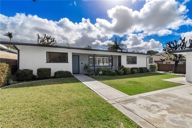 ranch-style home featuring fence, a chimney, a front lawn, and stucco siding