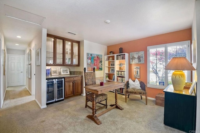 home office with light colored carpet, bar, and beverage cooler