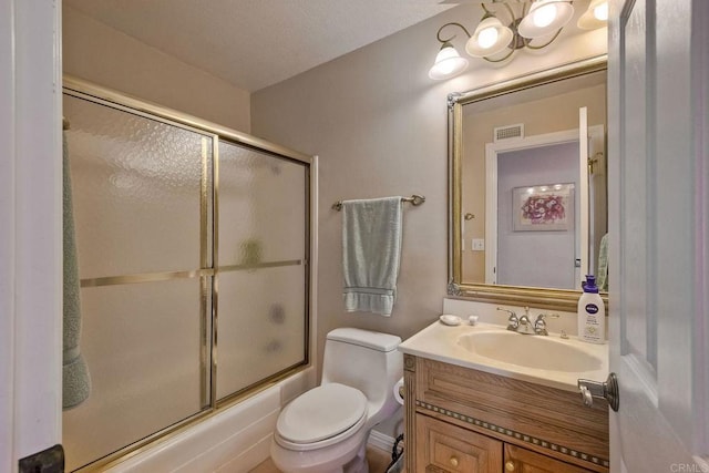 full bathroom featuring vanity, bath / shower combo with glass door, and toilet