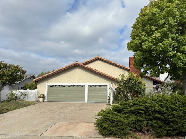 4217 Beach Bluff Rd, Carlsbad, CA 92008 - view of front of property with a chimney, stucco siding, a garage, and fence