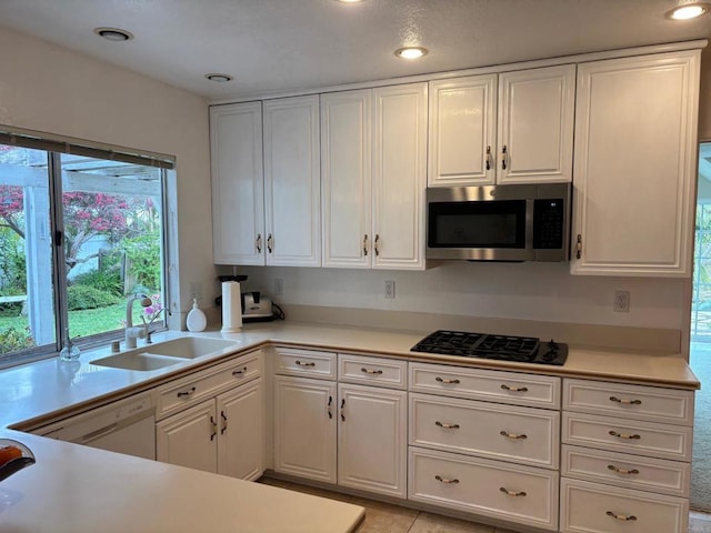 4217 Beach Bluff Rd, Carlsbad, CA 92008 - kitchen featuring stainless steel microwave, a sink, black gas cooktop, white cabinetry, and light countertops