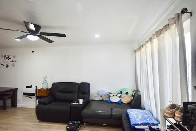 living room featuring crown molding, ceiling fan, and light wood-type flooring