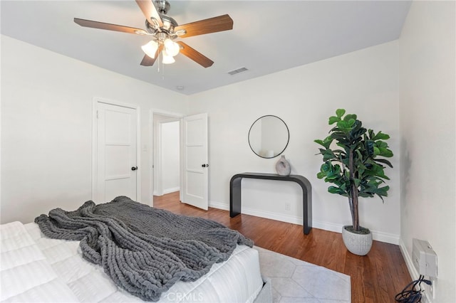 bedroom featuring visible vents, ceiling fan, baseboards, and wood finished floors