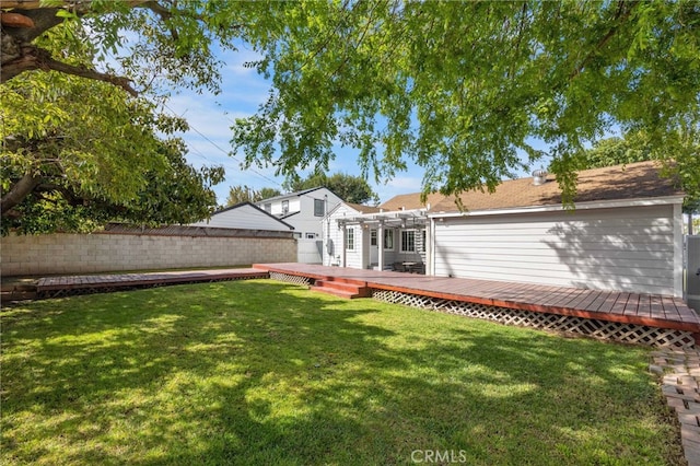 rear view of house featuring a yard, a deck, and a fenced backyard