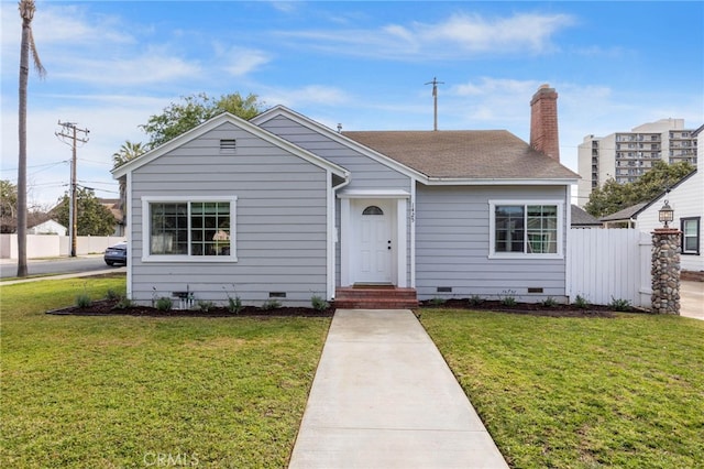 view of front facade with crawl space, a chimney, a front lawn, and fence